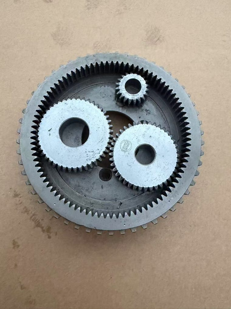 Textile machinery gear cluster with internal ring gear and matching pinions assembled in a housing